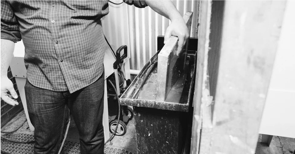 Cleaning out a screen in screen printing using a dip tank.